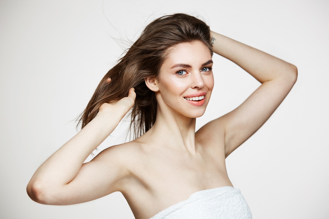beautiful-young-woman-with-perfect-clean-skin-smiling-touching-hair-white-wall-facial-treatment.jpg