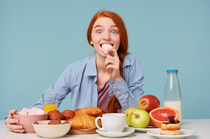 portrait-excited-red-haired-woman-holding-marshmallow-having-variable-breakfast.jpg