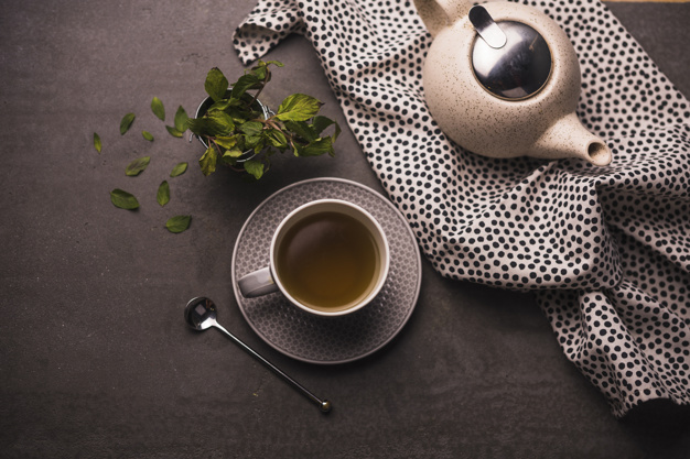 elevated-view-tea-leaves-teapot-polka-dotted-textile-table_23-2147975666.jpg